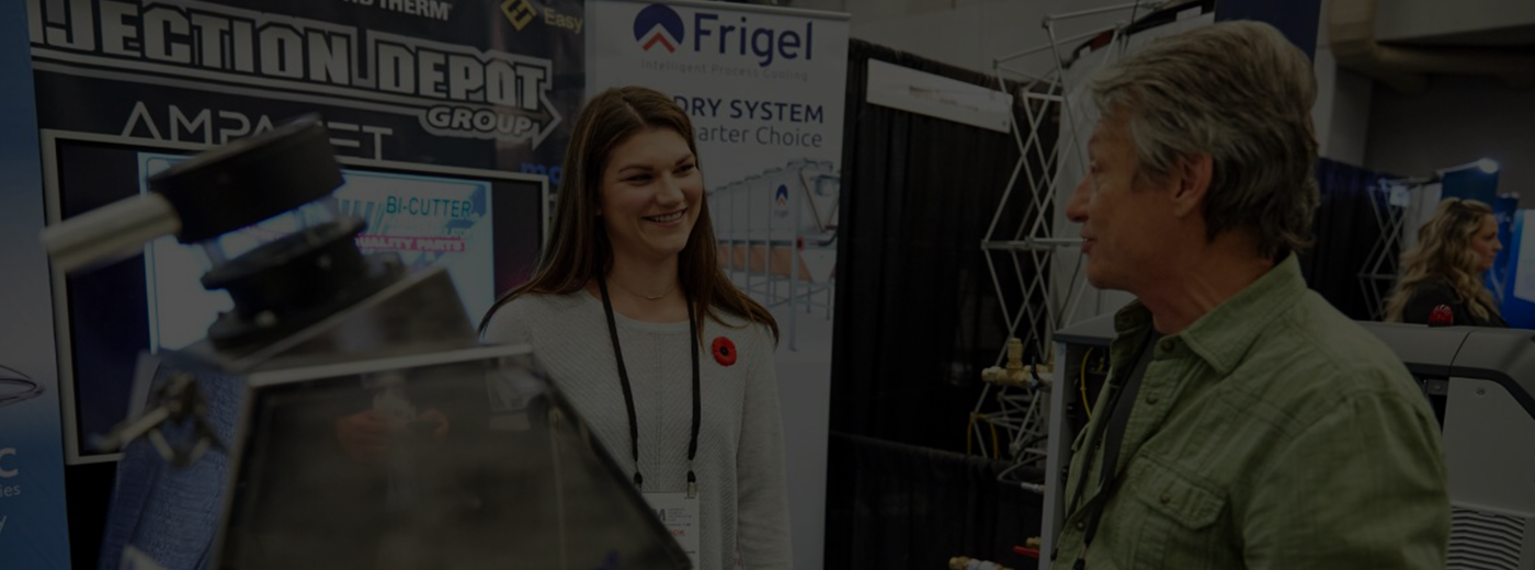 Woman and man talk at trade show over machine