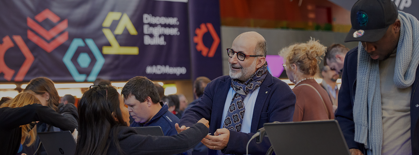 An expo attendee smiling and talking to a registration customer service representative 