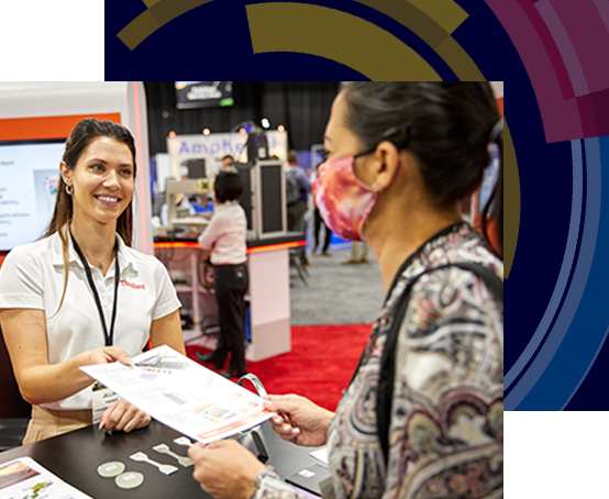 Exhibitor at tradeshow passing brochure to an attendee